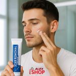 Mladi muškarac nanosi kremu za ožiljke na lice u kupatilu