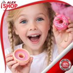 Devojčica pokazuje balzam za usne u obliku krofnice sa priveskom