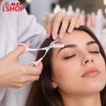 Profesionalna kozmetičarka koristi makaze za obrve sa češljićem u salonu