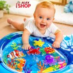 Krupan kadar bebe koja istražuje providnu prostirku sa vodom i šarenim morskim motivima.