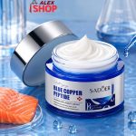 Blue Copper Peptide krema sa esencijom lososa okružena prirodnim sastojcima koji simbolizuju hidrataciju i negu kože.